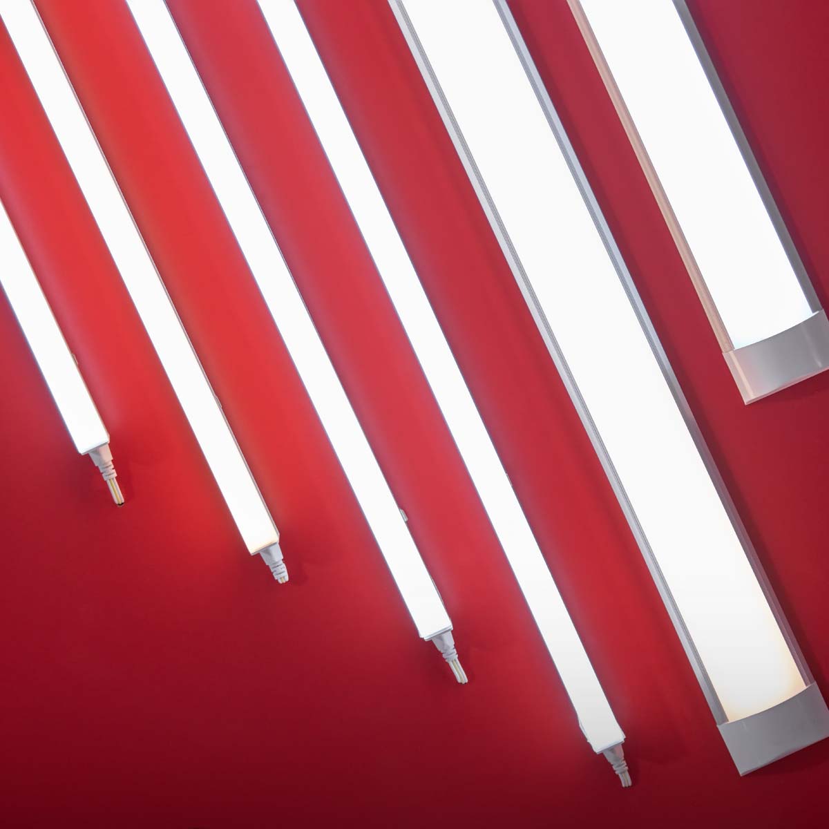 Set of neon energy saving LED tubes lights and lamps on a red ceiling